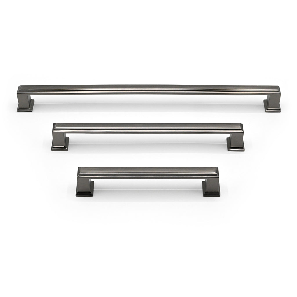Set of three metallic cabinet handles on a white background
