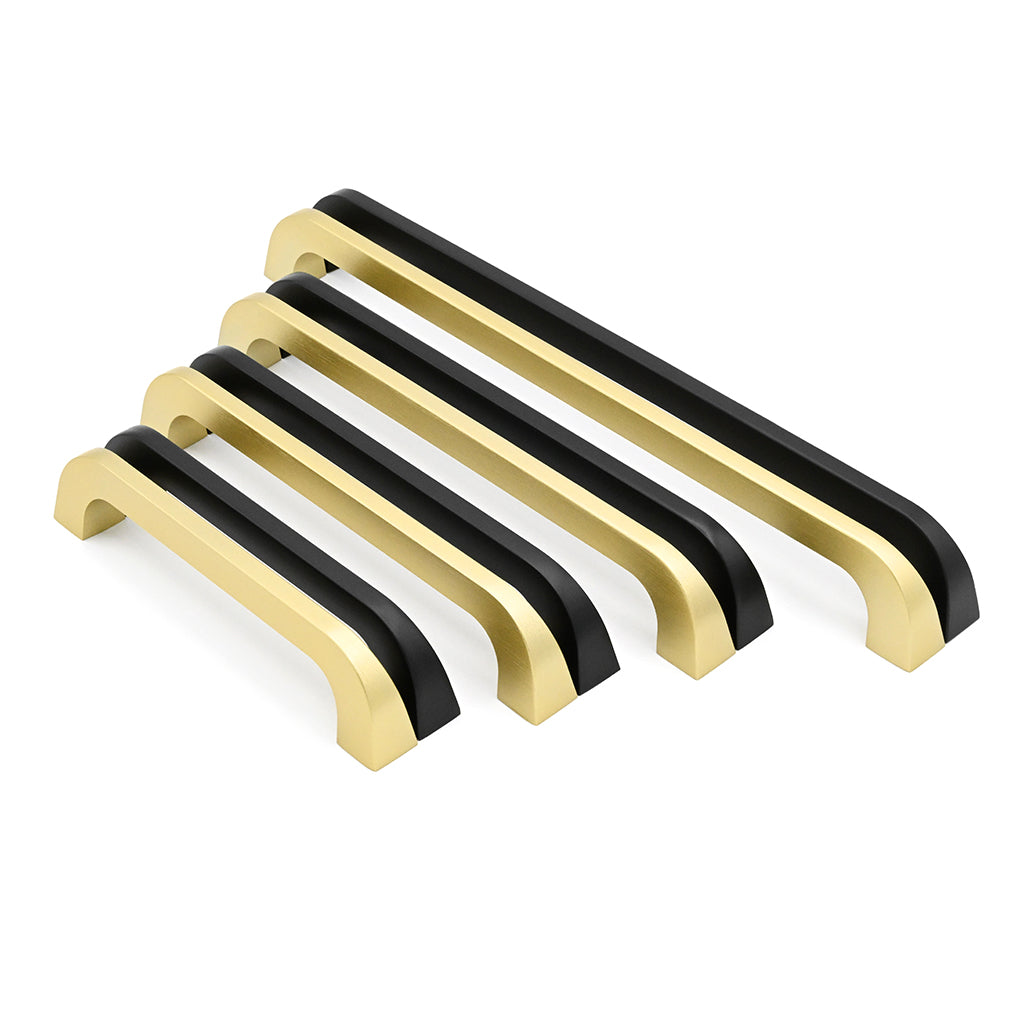 Set of gold and black cabinet handles on a white background