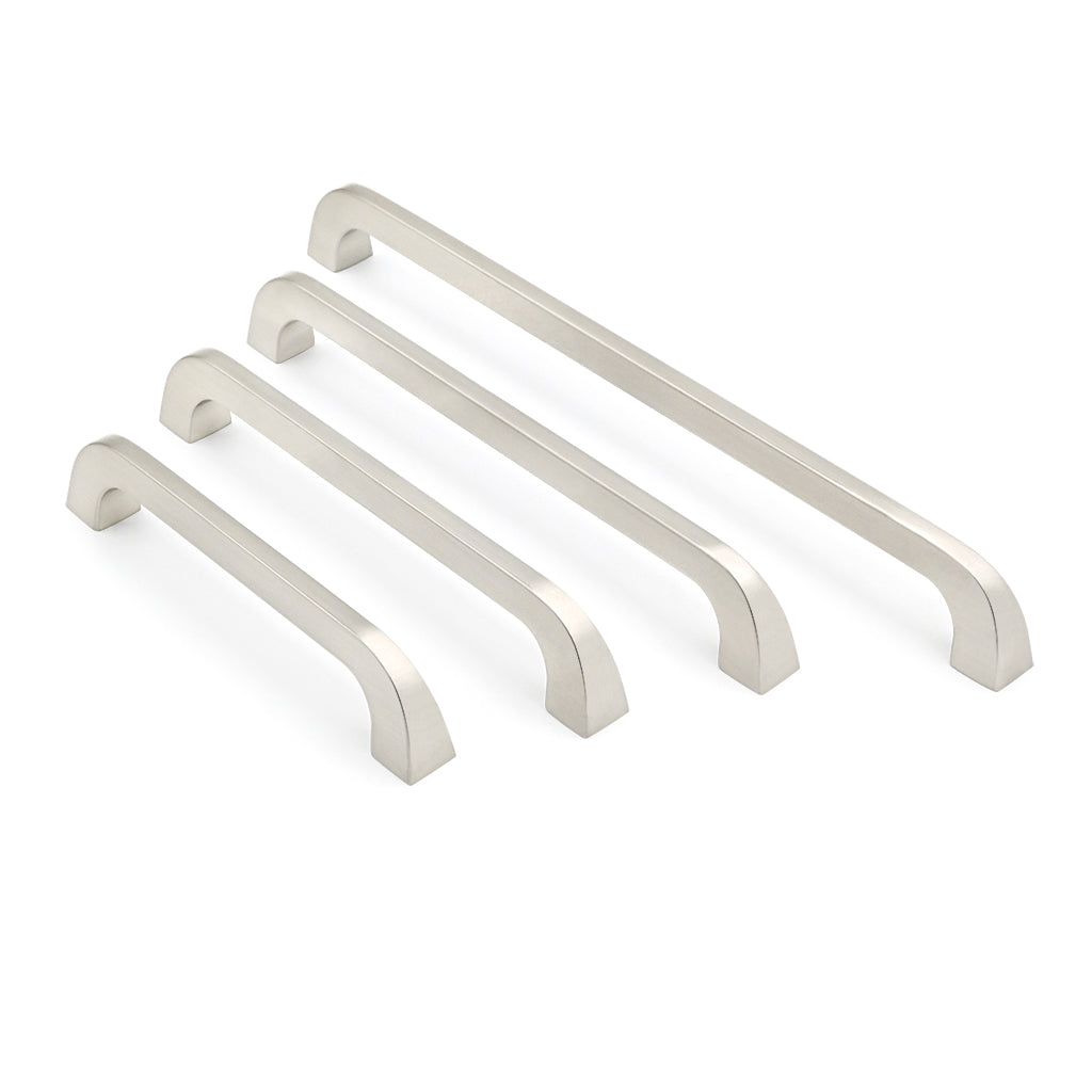Set of four metallic cabinet handles on a white background