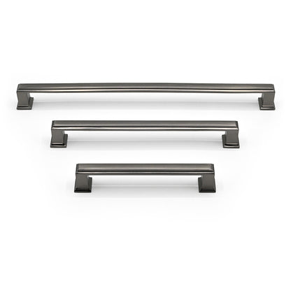 Set of three metallic cabinet handles on a white background